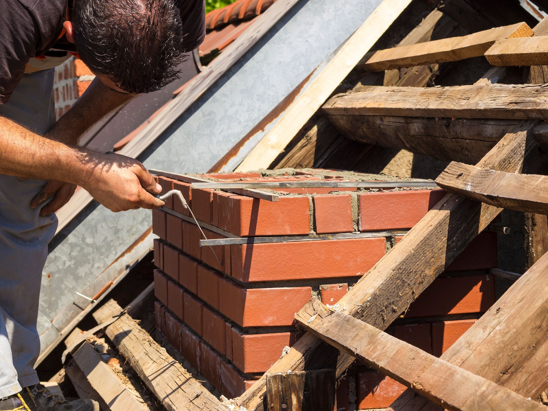Working detail on brick chimney on an old roof